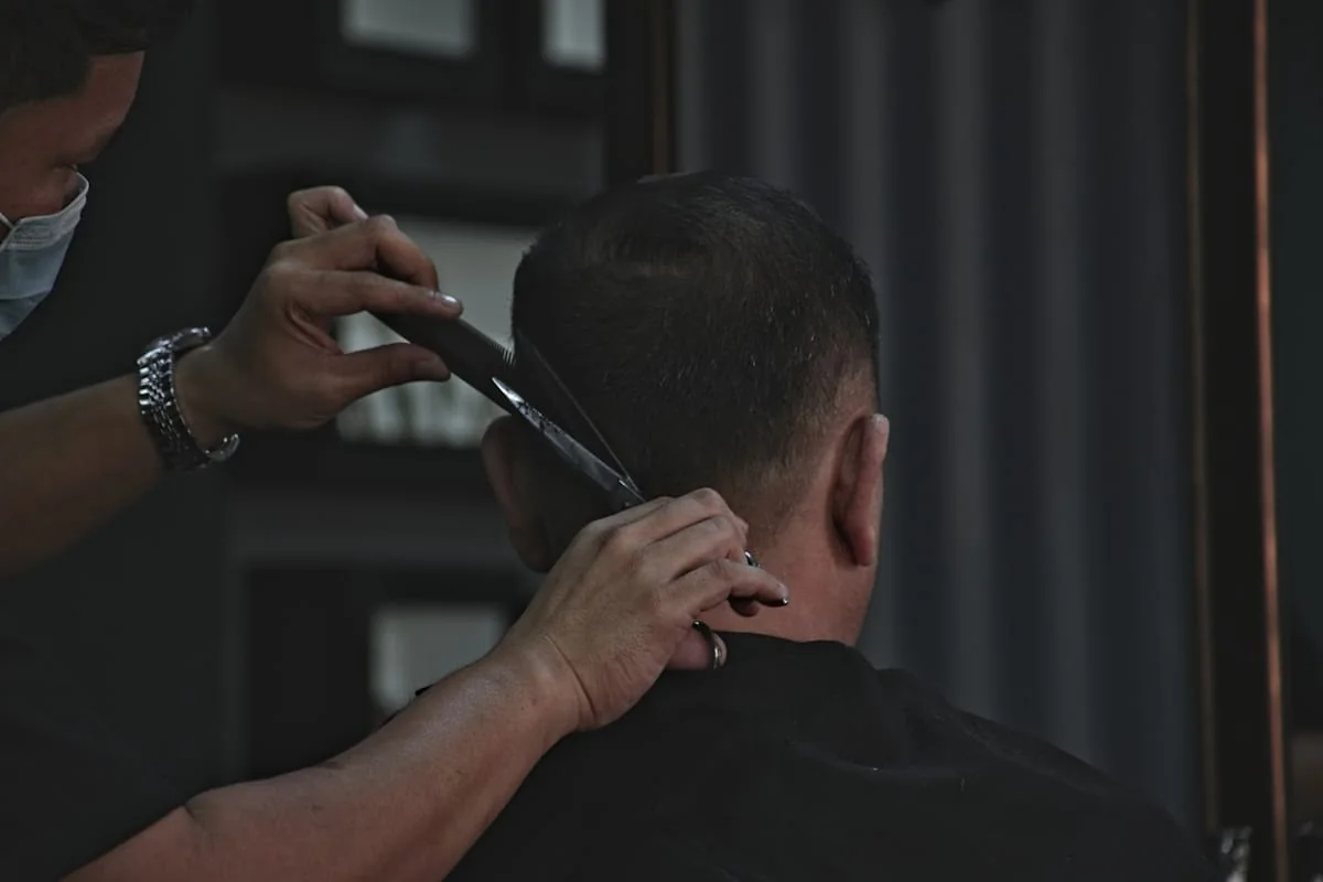 Close-up of a barber trimming hair