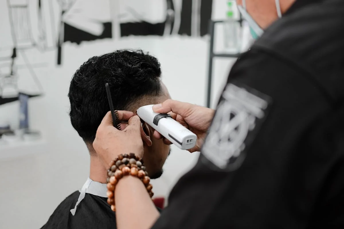 Barber trimming a client’s hair with clippers